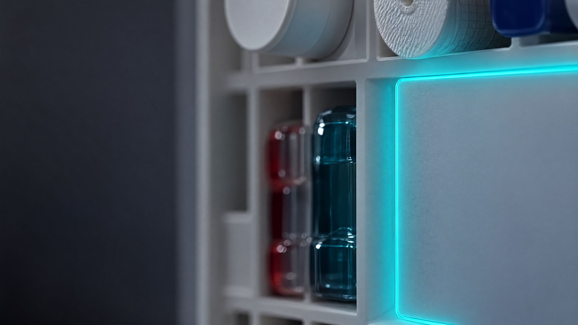 Close up at night: the cyan glow line of the open Solstis cabinet, beside its stocked compartments.